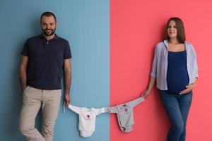 young couple holding baby bodysuits photo