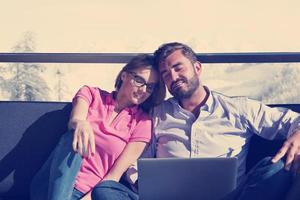 couple relaxing at  home using laptop computers photo