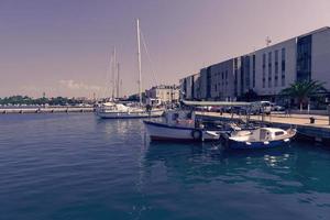 una fotografía de un barco y un yate de lujo anclados en el puerto. hermosa foto de un puerto mediterráneo