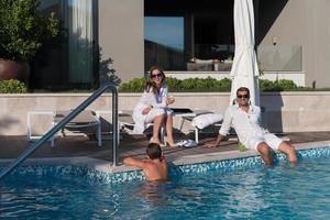 Happy family enjoys vacation in a luxury house with pool. Senior couple spends time with their son during the vacation. Selective focus photo