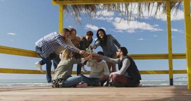 grupo de amigos divirtiéndose el día de otoño en la playa foto