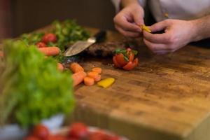 primer plano de las manos del chef preparando bistec de ternera foto