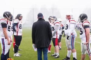 american football players discussing strategy with coach photo