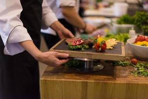 female Chef holding beef steak plate photo