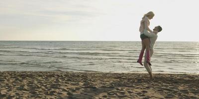 Loving young couple on a beach at autumn on sunny day photo