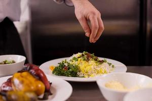 Chef hands serving vegetable risotto photo