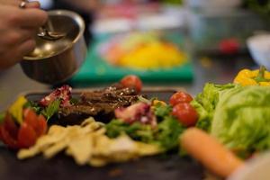 Chef finishing steak meat plate photo