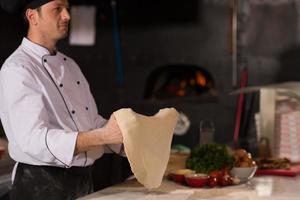 chef throwing up pizza dough photo