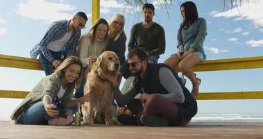 Group of friends having fun on autumn day at beach photo