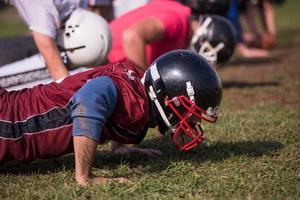 equipo de fútbol americano haciendo flexiones foto