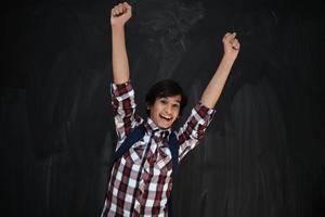 adolescente árabe feliz celebrando contra pizarra negra foto