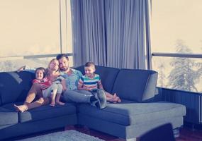 feliz pareja joven pasando tiempo con los niños en casa foto