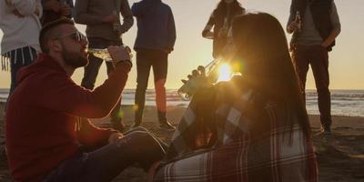 Friends having fun at beach on autumn day photo