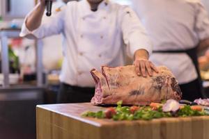 chef cutting big piece of beef photo