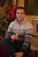 Happy young man with a glass of champagne photo