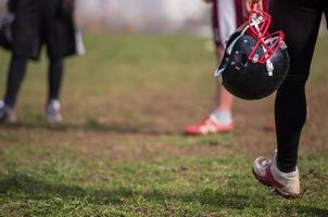 American football player holding helmet photo