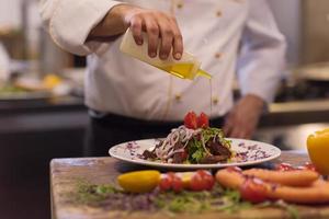 Chef finishing steak meat plate photo