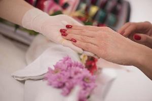 manos de mujer recibiendo una manicura foto