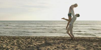 Loving young couple on a beach at autumn on sunny day photo