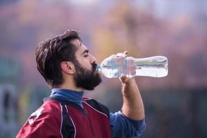 american football player drinking water after hard training photo