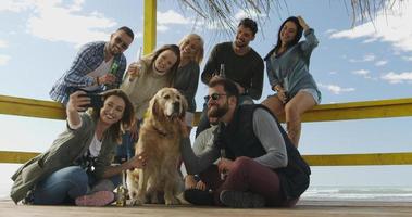 grupo de amigos divirtiéndose el día de otoño en la playa foto