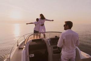 una pareja mayor con ropa informal con su hijo disfruta mientras viaja en un bote en el mar al atardecer. el concepto de una familia feliz. enfoque selectivo foto