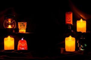Selective focus on the front orange color Jack o lantern with blurred focus candles for Scary halloween background concept. photo
