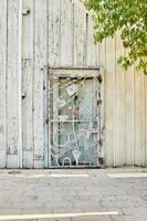 Metal door made of different figures at the entrance to wooden house made of rough wood photo