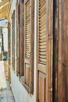 Wooden windows and brown shutters in house at sunset photo