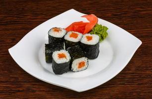 maki de salmón en el plato y fondo de madera foto