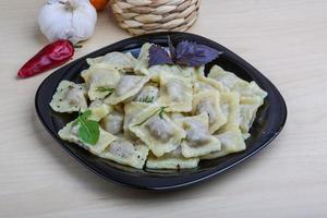 Ravioli on the plate and wooden background photo