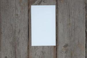 on a wooden background a sheet of white paper vertically for writing photo