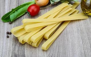 Fettuccine on wooden background photo