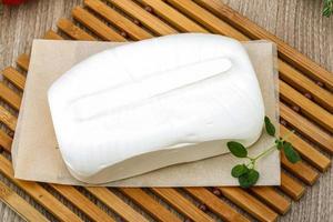 Feta cheese on wooden board and wooden background photo