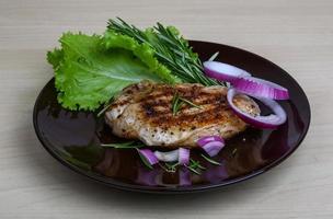 Pork steak on the plate and wooden background photo