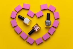 Nail manicure buffs and varnishes of pink color in the form of heart photo