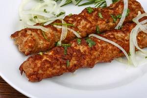 Beef kebab on the plate and wooden background photo