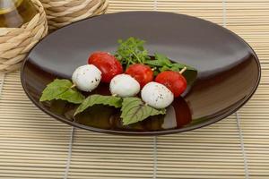 ensalada caprese en el plato y fondo de madera foto