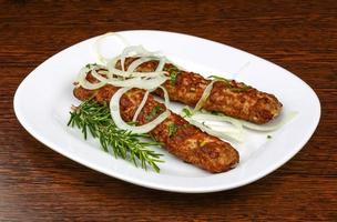 Beef kebab on the plate and wooden background photo