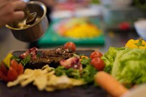 Chef finishing steak meat plate photo