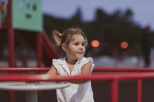 A little girl in modern summer clothes playing in the park in summer. Selective focus photo