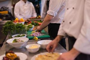 equipo de cocineros y chefs preparando comida foto