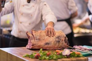 chef cutting big piece of beef photo
