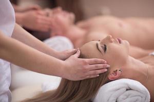 pareja disfrutando de un masaje de cabeza en el spa foto