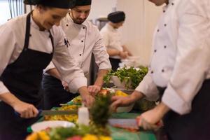 equipo de cocineros y chefs preparando comida foto