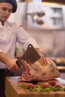 chef cutting big piece of beef photo