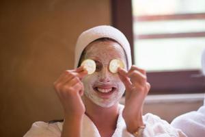 woman is getting facial clay mask at spa photo