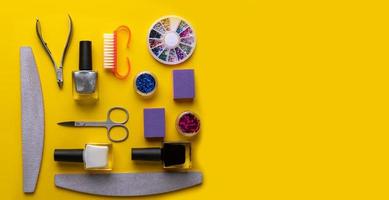 manicure and pedicure tools and accessories on yellow background top view. photo