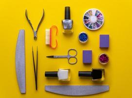 manicure and pedicure tools and accessories on yellow background top view. photo