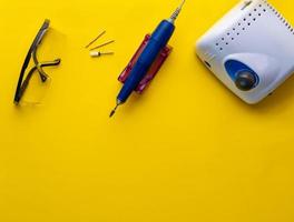 Top view of manicure and pedicure equipment on yellow background photo